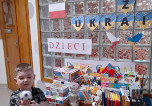 Chłopiec pokazuje prezent przyniesiony dla dzieci z Ukrainy